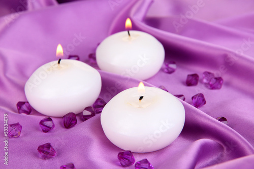 Candles on purple fabric close-up