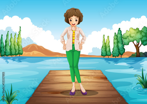 A woman standing above the wooden bridge at the river