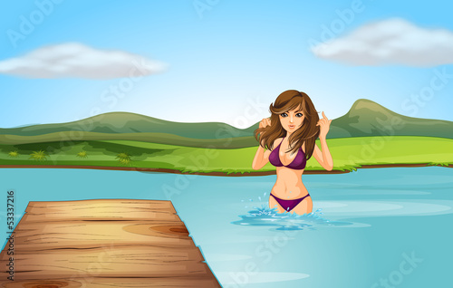 A girl at the beach with a wooden diving board