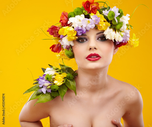 Summer young woman with colorful flowers in hair.