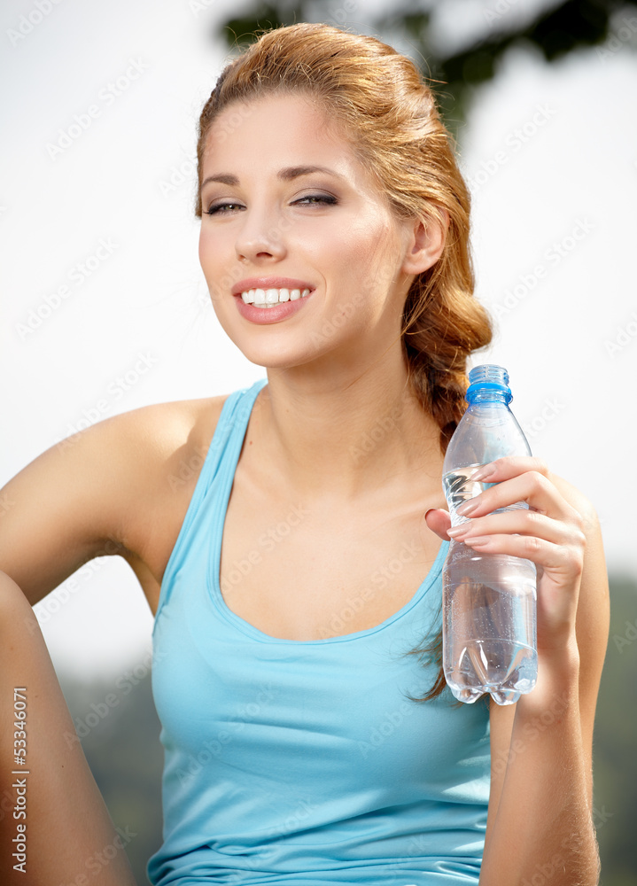 Young beautiful woman drinking water after fitness exercise outd Young beautiful woman drinking water after fitness exercise outd
