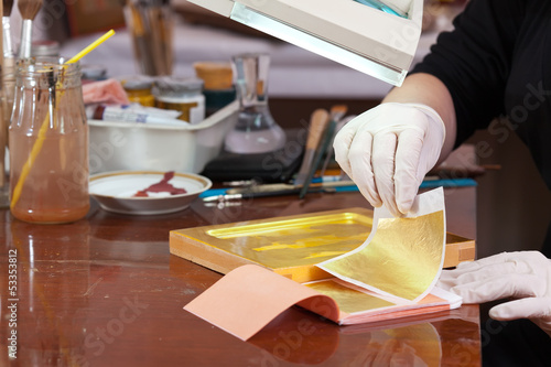 Iconographer gilding on the Christian icon photo