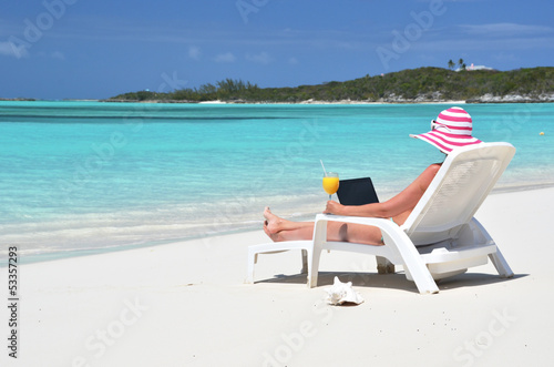 Fototapeta Naklejka Na Ścianę i Meble -  Girl with a laptop on the tropical beach. Exuma, Bahamas
