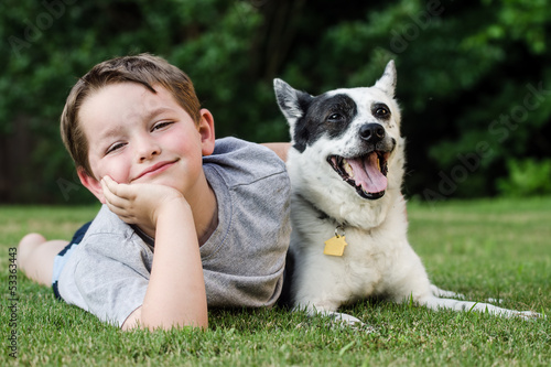 Child playing with his pet dog, a blue heeler