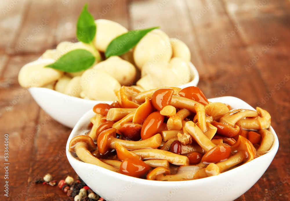 Mushrooms in bowls, on wooden background Mushrooms in bowls, on wooden background