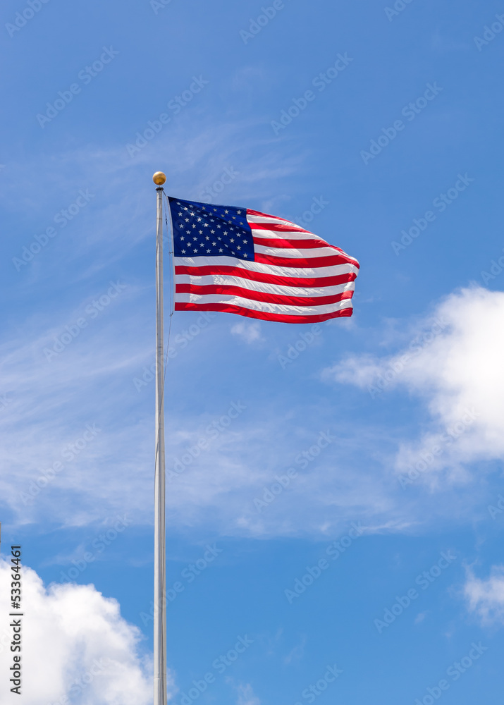 American Flag on Flagpole Waving in Blue Sky