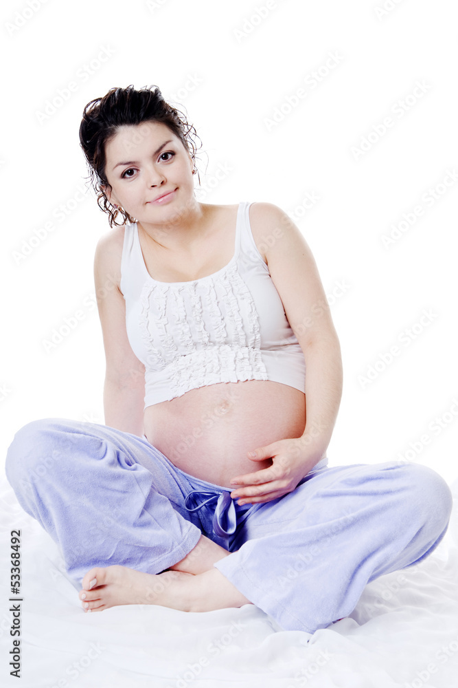 Young pregnant woman sitting on sofa. looking at camera.isolated Young pregnant woman sitting on sofa. looking at camera.isolated