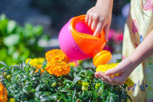 Girl watering flowers with a watering can