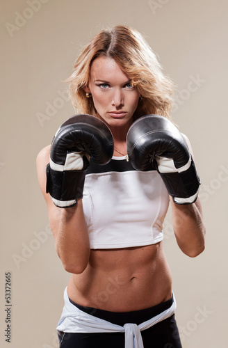 Portrait of blonde sportish woman in boxing gloves © Svyatoslav Lypynskyy