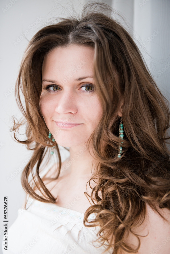 Obraz premium Portrait of beautiful young happy smiling woman with long curly