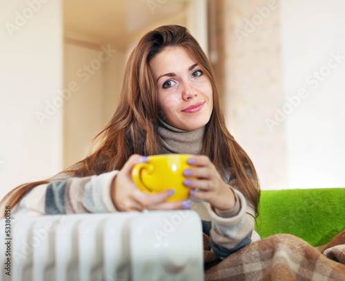 woman  near oil heater at home photo