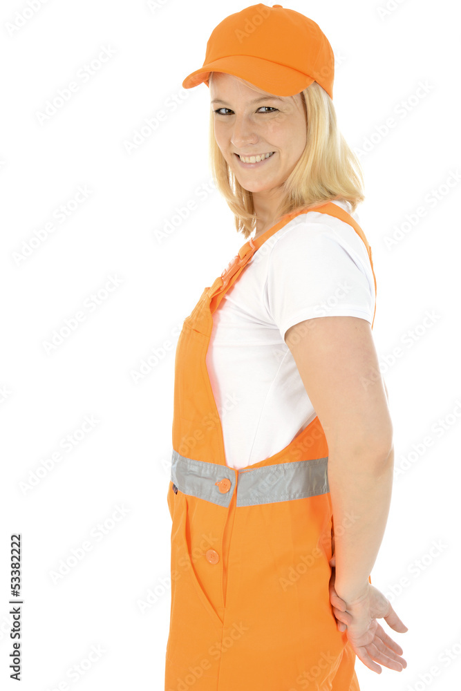 Freundliche Bauarbeiterin in oranger Latzhose Freundliche Bauarbeiterin in oranger Latzhose