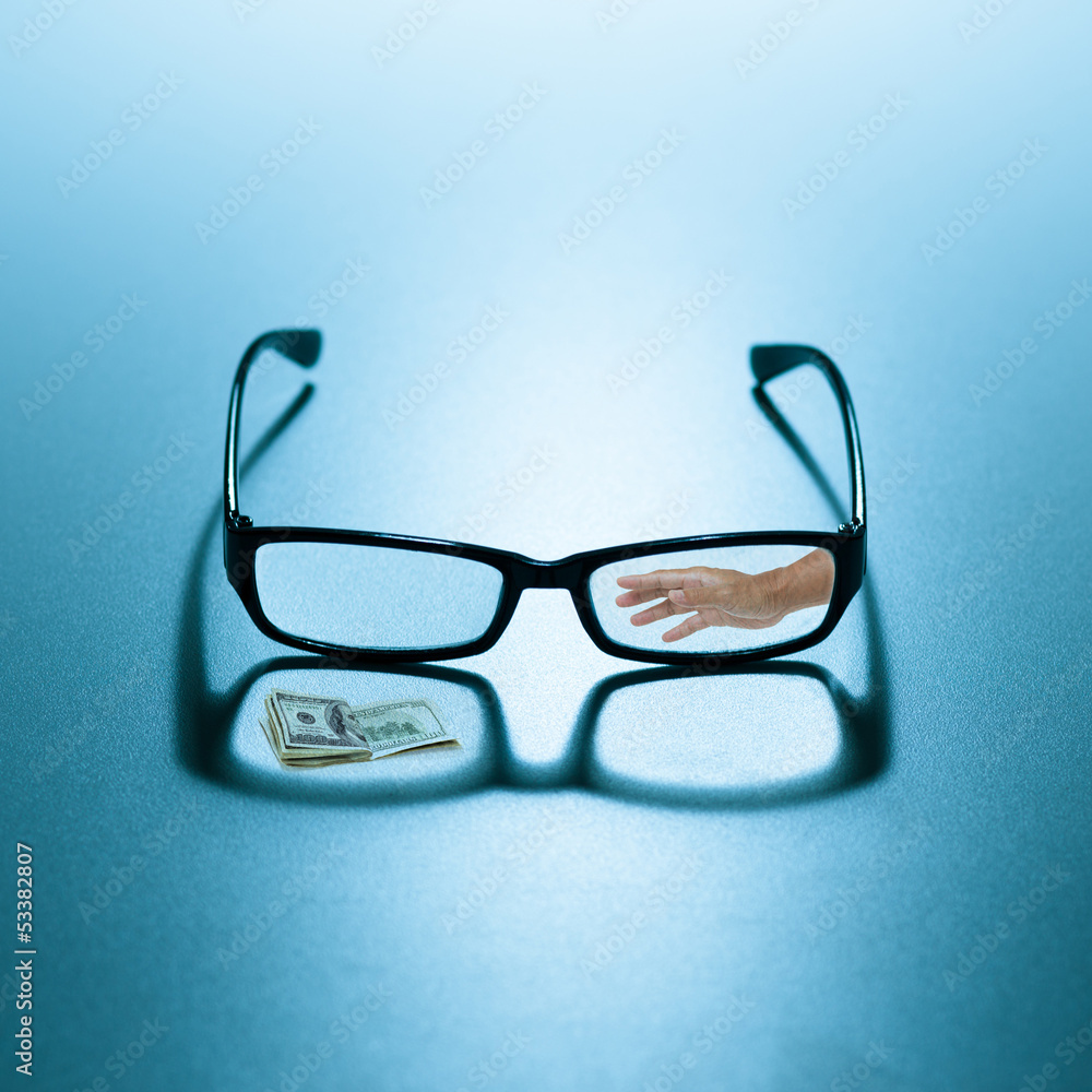 Reading eyeglasses with hand and 100 dollar bills Reading eyeglasses with hand and 100 dollar bills