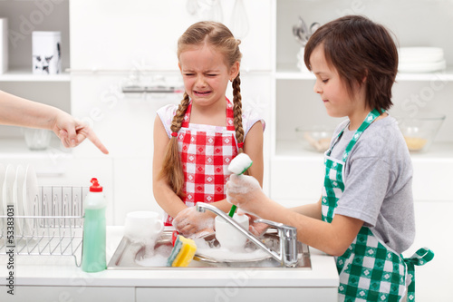 Fotografie Do the dishes - kids ordered to help in the kitchen