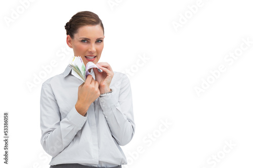 Businesswoman counting money and looking at camera