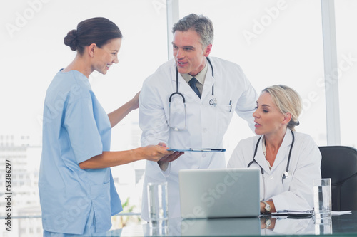 Nurse giving folder to her colleagues