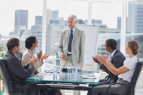 Colleagues applauding the boss during a meeting