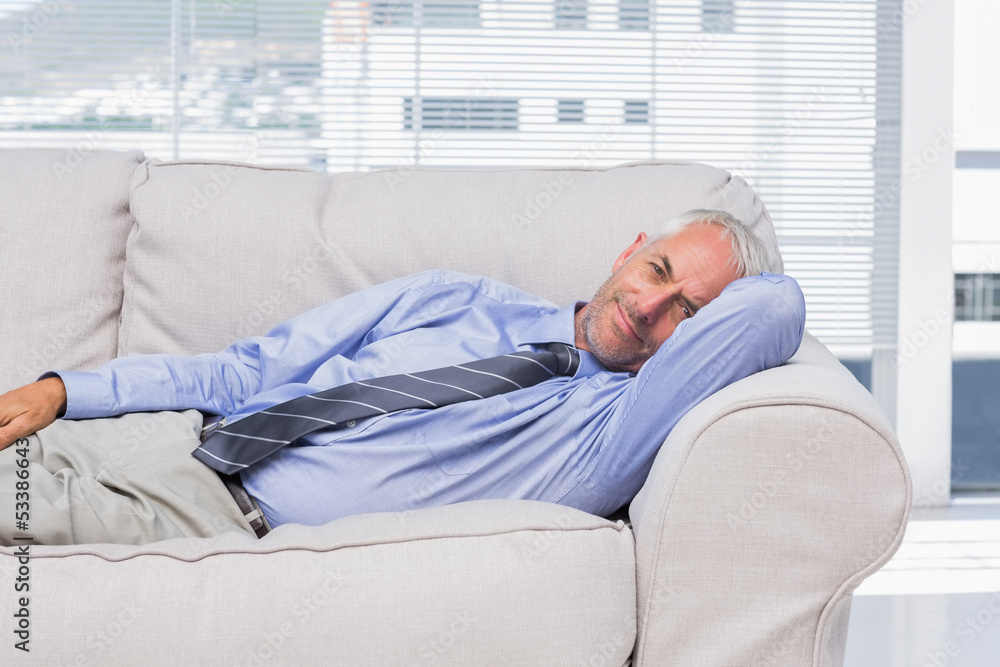 Businessman lying on sofa resting Businessman lying on sofa resting