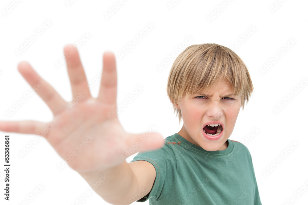 Furious little boy shouting and making stop sign with hand Furious little boy shouting and making stop sign with hand