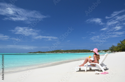 Girl with a glass of orange on the beach of Exuma, Bahamas © HappyAlex