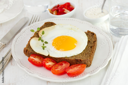 egg with black bread and tomato cherry