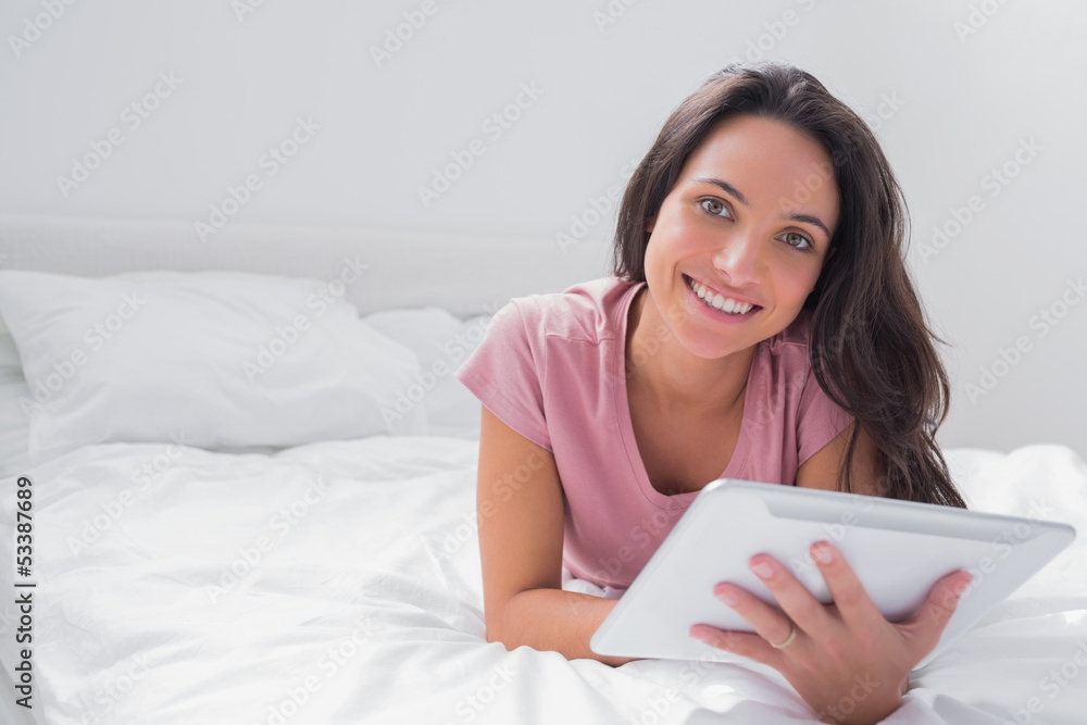 Woman using a tablet pc in her bed Woman using a tablet pc in her bed
