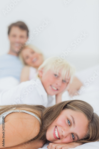 Smiling siblings lying on the bed