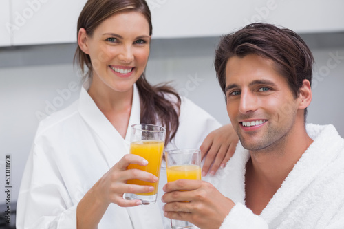 Couple holding glass of orange juice