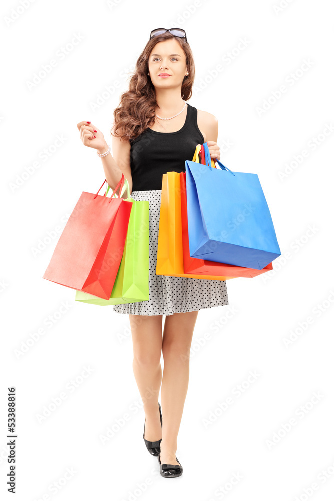 Full length portrait of a young woman walking with shopping bags