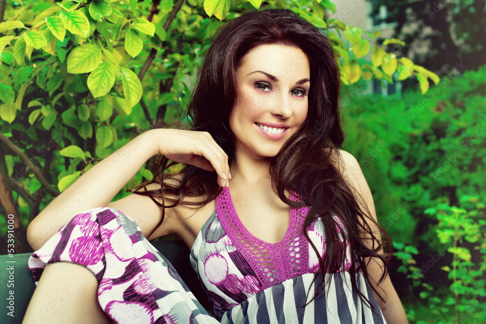 beautiful woman smiling and sitting on a bench in the park beautiful woman smiling and sitting on a bench in the park