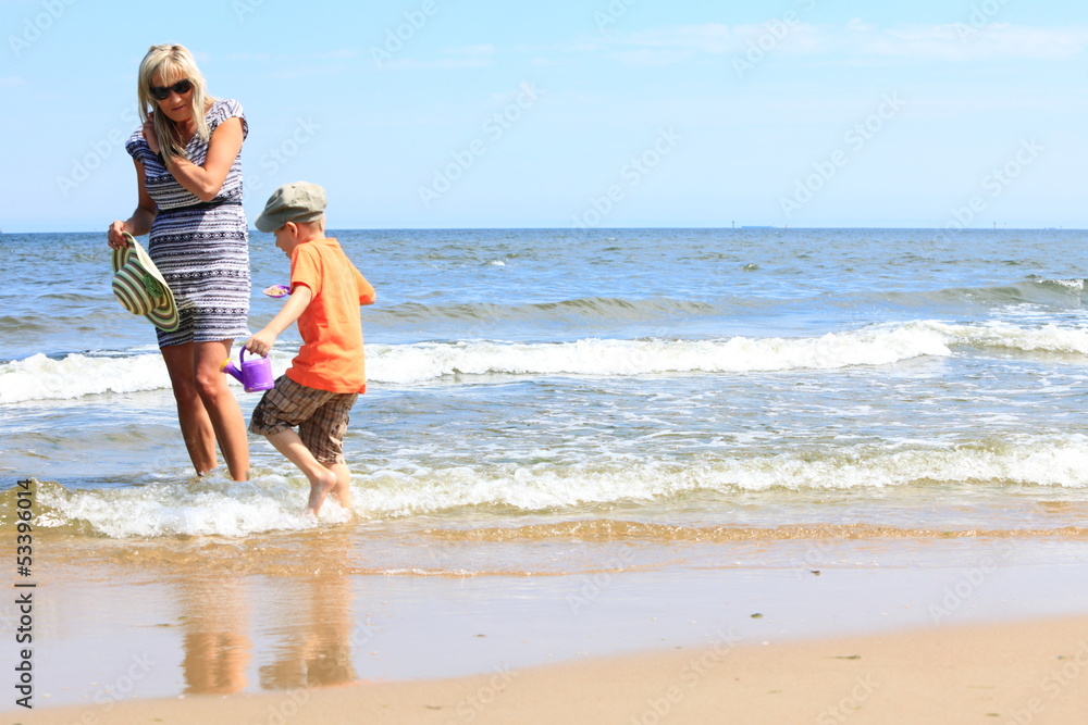 happy mother and son playing on beach