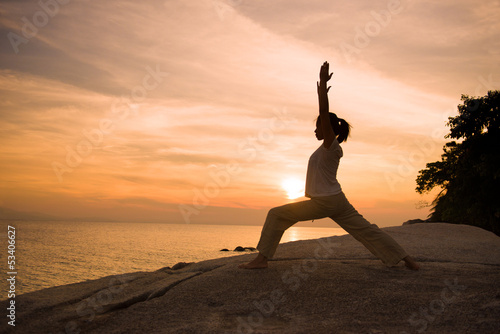 silhouette girl posing yoga on beautiful beach during sunset