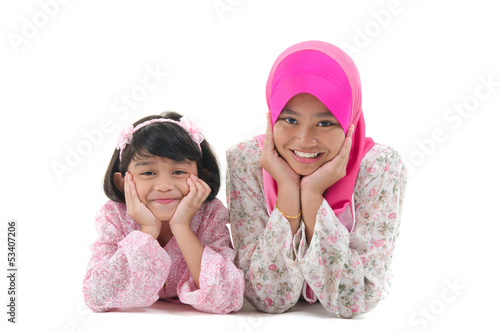 malay sisters laying on the floor with isolated white background photo