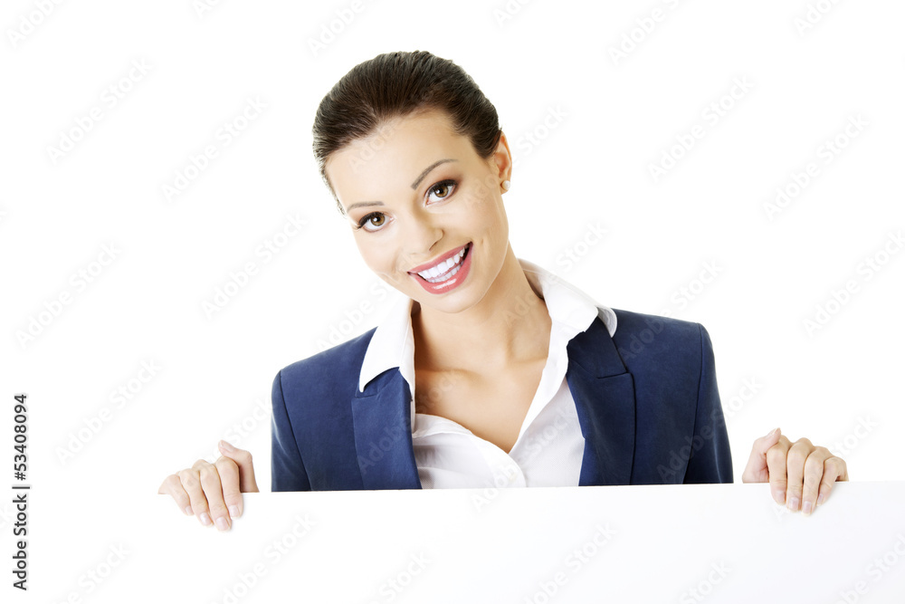 Smiling businesswoman showing blank signboard Smiling businesswoman showing blank signboard
