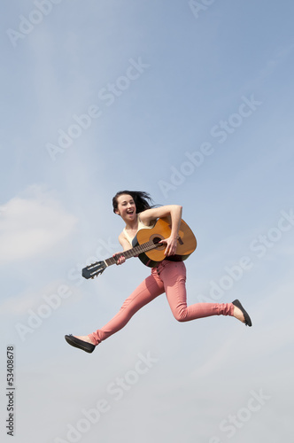Frau springt mit Gitarre