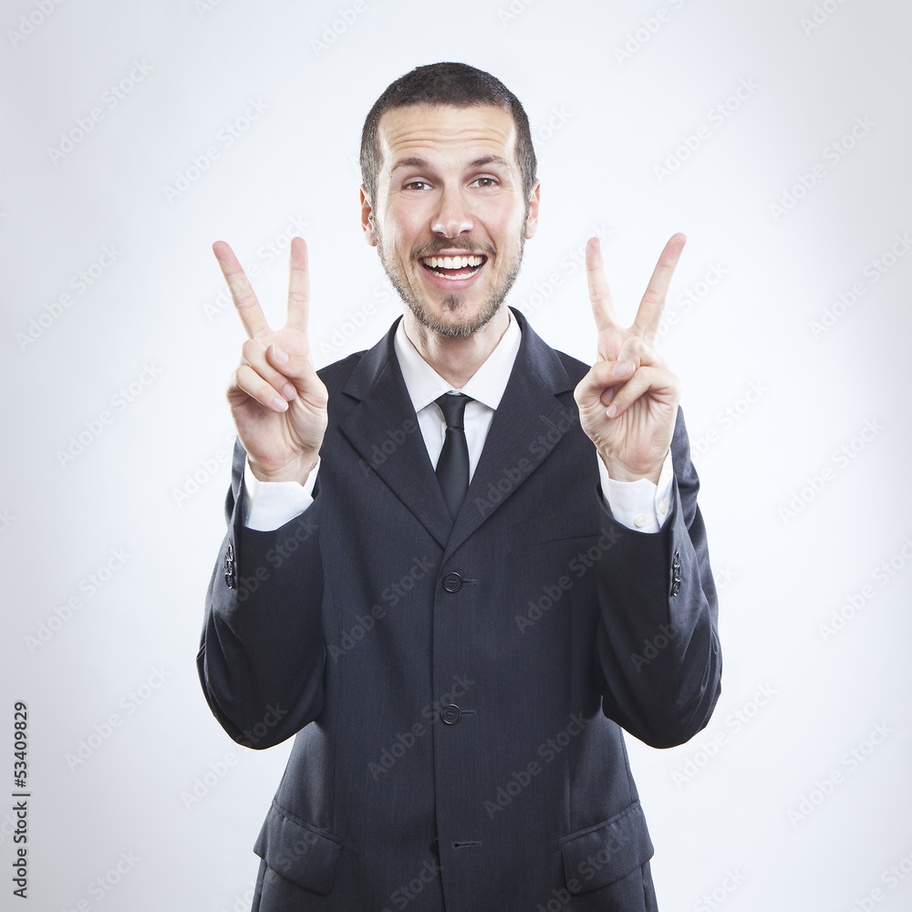 Smiling young businessman, victory sign Smiling young businessman, victory sign