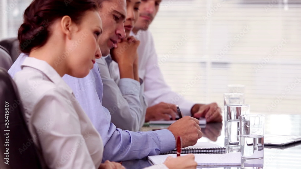 Business people taking notes during a meeting Business people taking notes during a meeting