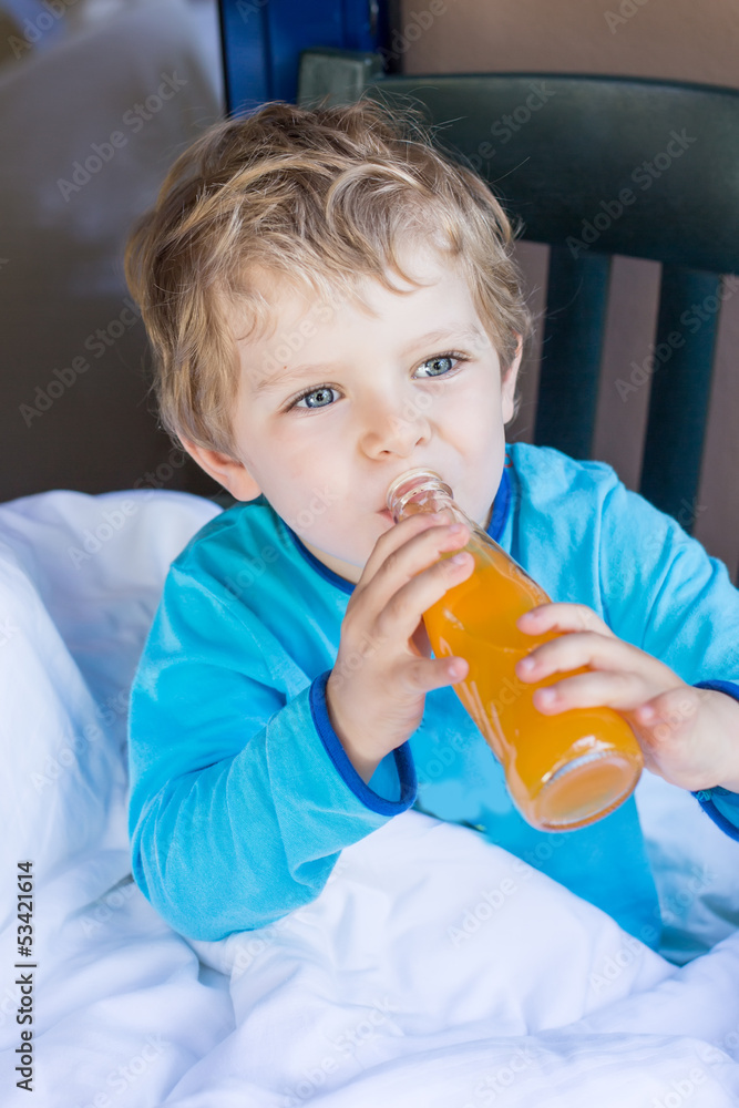 Happy little boy drinking orange juice on balcony Happy little boy drinking orange juice on balcony