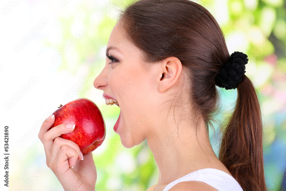 Young woman with apple on bright background Young woman with apple on bright background