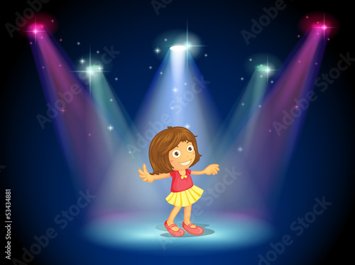 A little girl dancing in the middle of the stage with spotlights