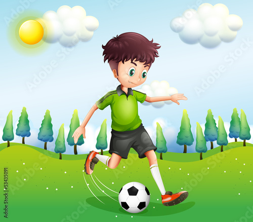 A boy playing football in the hill