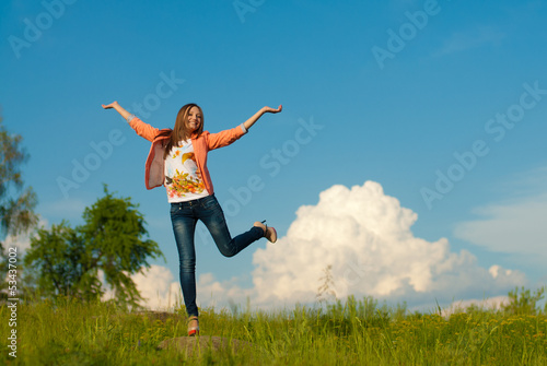 happy teenage girl jumping on the summer outdoors background