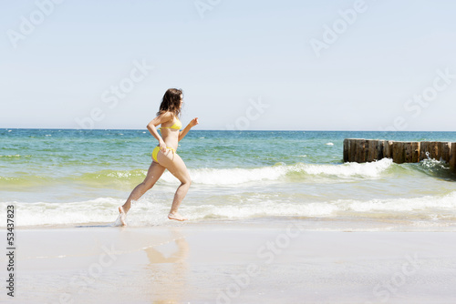 happy woman running on the beach