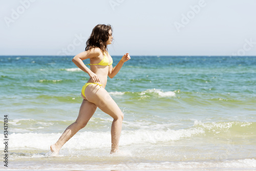happy woman running on the beach © Piotr Marcinski