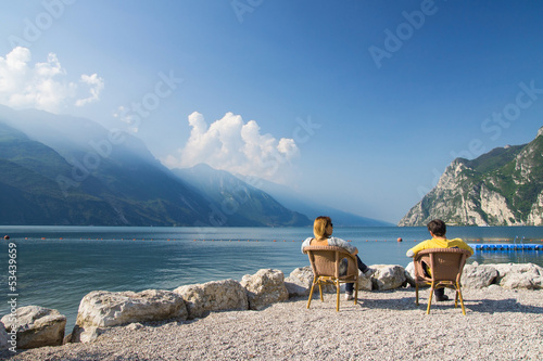 man and woman sitting at the lake garda, italien