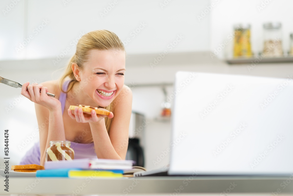 Laughing young woman spread toast with chocolate cream