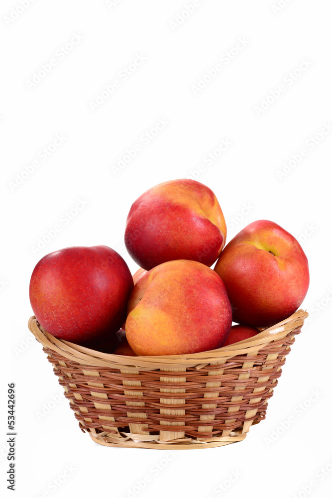 Fresh fruit nectarines in the basket, on white background Fresh fruit nectarines in the basket, on white background
