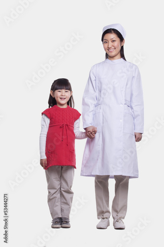 Portrait of nurse and child holding hands, studio shot