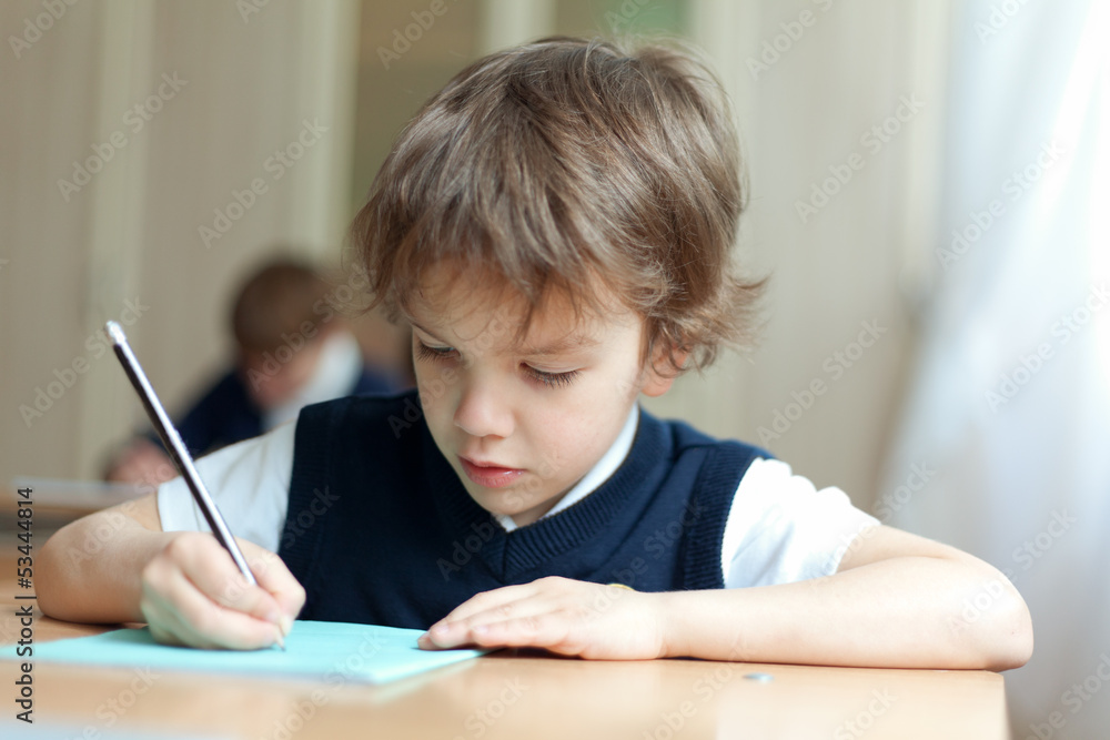 Diligent student sitting at desk, classroom Diligent student sitting at desk, classroom