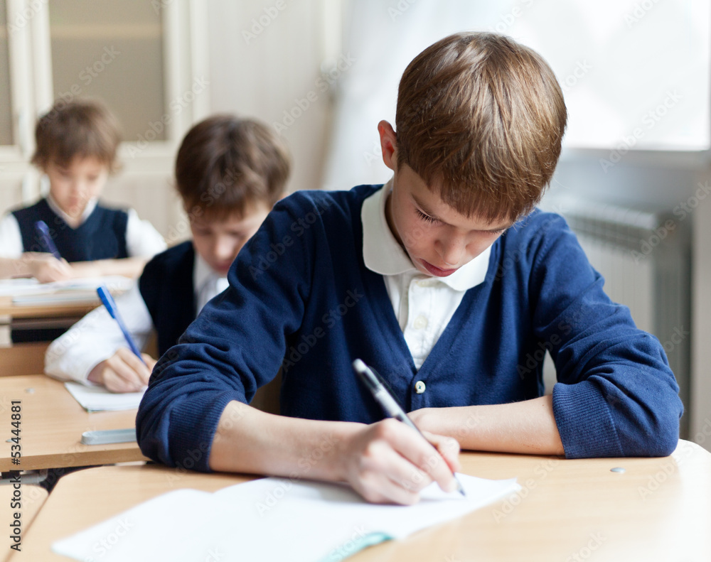 Diligent student sitting at desk, classroom Diligent student sitting at desk, classroom